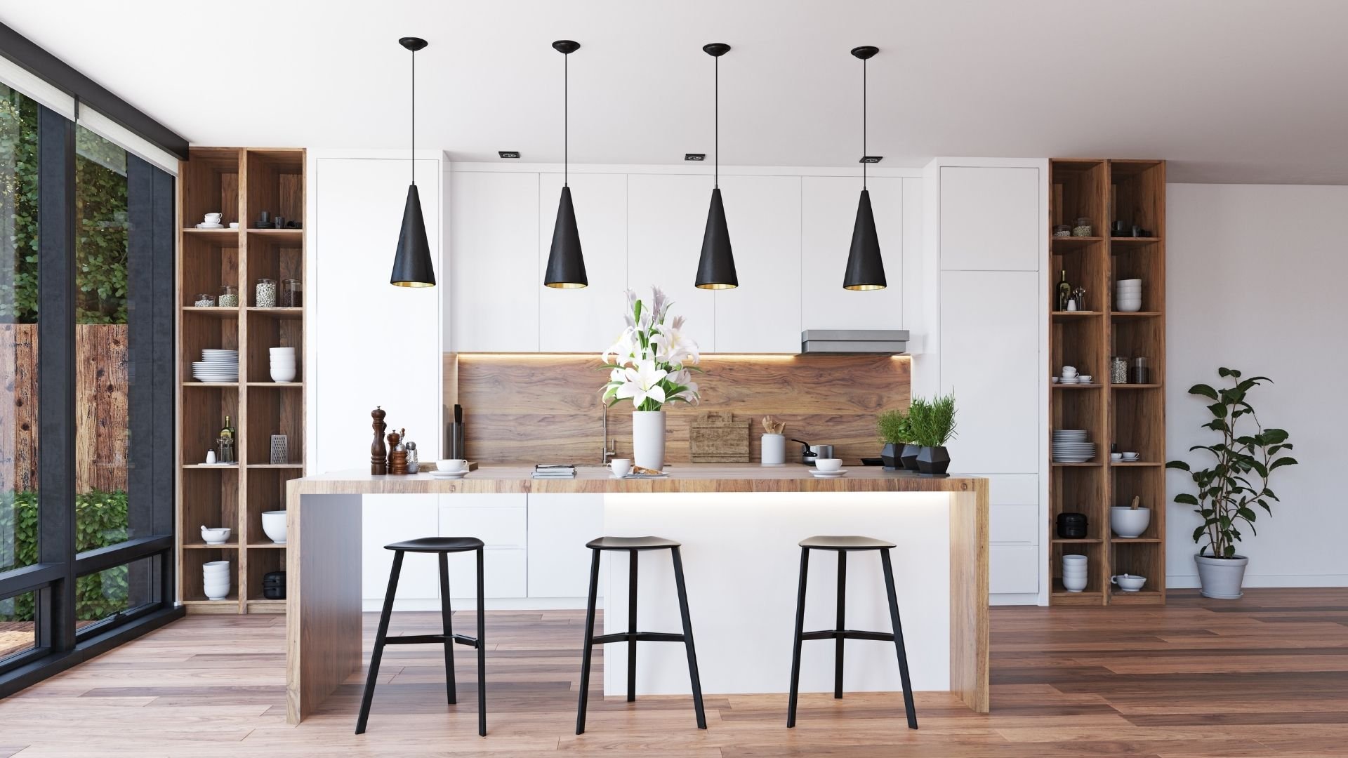 Modern kitchen with white cabinets, wood island, black pendant lights, and bar seating.