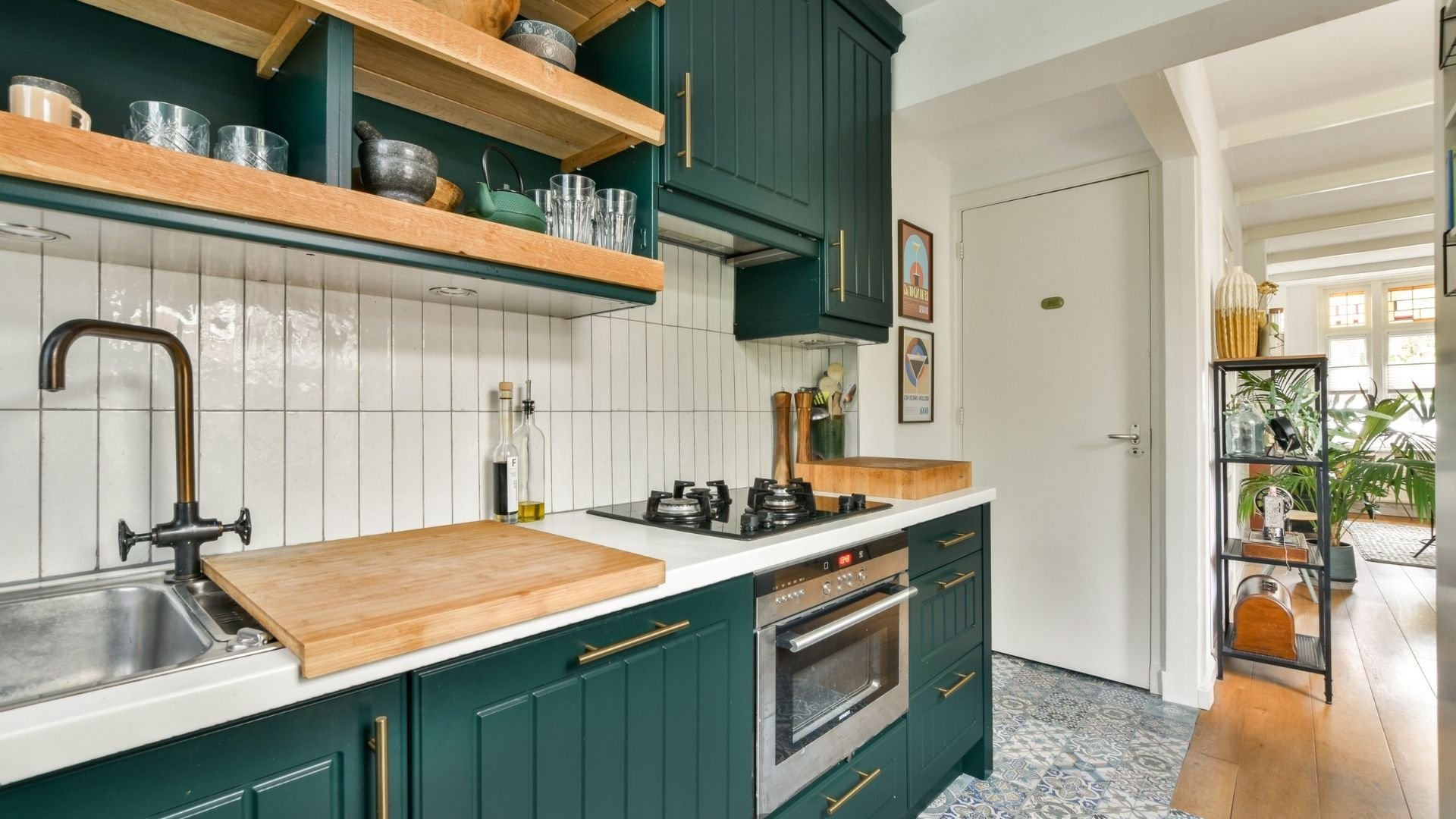Modern kitchen with green cabinets, wooden countertops, white subway tile backsplash, and open shelving.